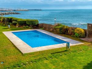 a swimming pool with the ocean in the background at Apartment Blaumar by Interhome in Sant Andreu de Llavaneres