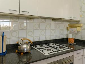 y cocina con fogones y hervidor de agua. en Apartment Vallpineda San Fermin by Interhome, en Sitges