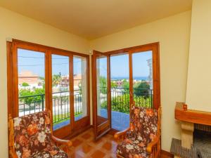 Habitación con 2 sillas y balcón con ventanas. en Holiday Home Angel Guimera by Interhome, en Creixell