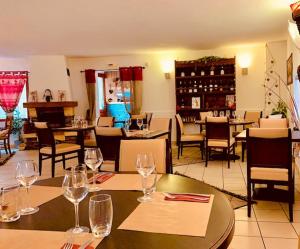 un restaurante con una mesa con copas de vino. en Auberge La Cascade en Avrieux