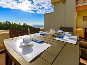 una mesa con tazas y platillos encima en Apartment Vallpineda San Fermin by Interhome, en Sitges