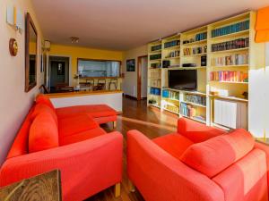 una sala de estar con muebles de color naranja y estanterías en Apartment Vallpineda San Fermin by Interhome, en Sitges