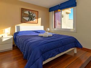 Un dormitorio con una cama azul y una ventana en Apartment Vallpineda San Fermin by Interhome, en Sitges