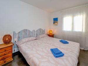 a bedroom with a large bed with blue towels on it at Apartment Blaumar by Interhome in Sant Andreu de Llavaneres