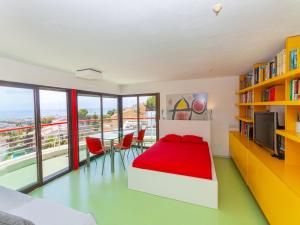 シッチェスにあるVilla Vallpineda Avenida Miquel Utrillo by Interhomeのベッドルーム1室(赤いベッド1台、テーブル、椅子付)