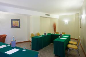 a room filled with tables, chairs, and tables at Holiday Inn Cagliari, an IHG Hotel in Cagliari