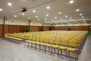an empty room with yellow chairs in a hall at Holiday Inn Cagliari, an IHG Hotel in Cagliari