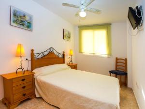 1 dormitorio con 1 cama, TV y ventana en Apartment Oroblanc by Interhome, en Oropesa del Mar