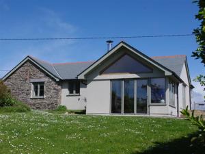 a house with large windows on a lawn at Holiday Home Farmlans by Interhome in Saint Merryn