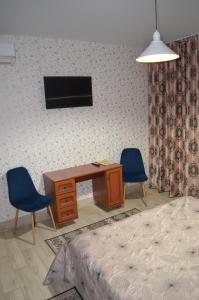 a bedroom with a desk and two chairs and a bed at Motel Chalet in Vita-Pochtovaya