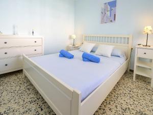 1 dormitorio blanco con 1 cama grande con almohadas azules en Apartment Costa Playa by Interhome, en Cunit