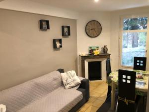 a living room with a couch and a clock on the wall at La Sala in Amélie-les-Bains-Palalda