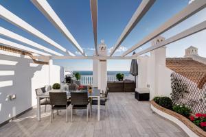 ein Esszimmer mit einem Tisch und Stühlen auf einer Terrasse in der Unterkunft Balcón de Benalmádena in Benalmádena