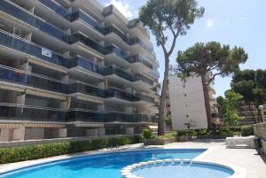 an apartment with a swimming pool in front of a building at Zeus Montblanc in Salou