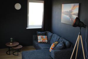 a living room with a blue couch and a window at Wijnberg Appartementen in Hollum
