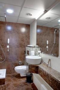 a bathroom with a sink and a toilet and a mirror at Landmark Hotel in Dubai