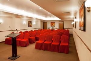 a conference room with red chairs and a podium at Landmark Hotel in Dubai