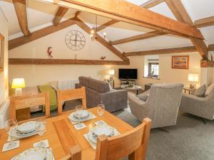 a living room with a wooden table and chairs at The Studio Malt Kiln Cottages in Grizebeck