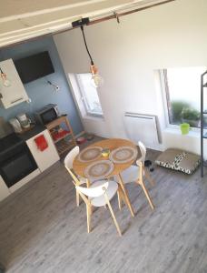 a table and chairs in a room with a kitchen at Gîte de la Carnoy in Ennetières-en-Weppes