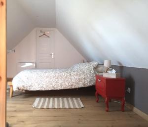 een slaapkamer met een bed en een rode nachtkastje bij Gîte de la Carnoy in Ennetières-en-Weppes