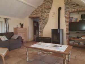 sala de estar con sofá y chimenea en Gîtes Les Myosotis, en Morhet