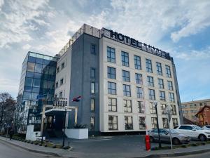 un gran edificio blanco con un cartel. en Hotel Avenue - Avenue Hotels, en Buzău