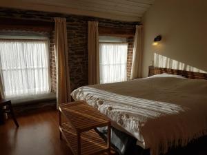 a bedroom with a large bed and two windows at Gîtes Les Myosotis in Morhet