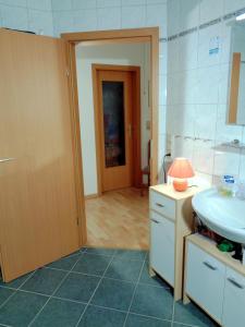 a bathroom with a sink and a toilet and a door at Gästehaus Schiemann in Teterow +68 photos