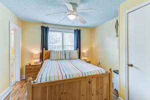 a bedroom with a bed with a ceiling fan and a window at The Folly House in Folly Beach
