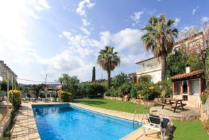 - une piscine dans une cour avec des palmiers dans l'établissement Club Villamar - Citron, à Calonge