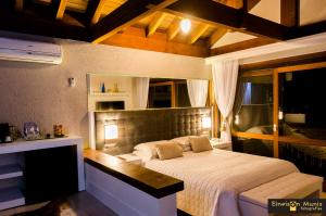 a bedroom with a large bed in a room at Solar Mirador Exclusive Resort e SPA in Praia do Rosa