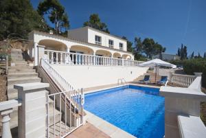 a villa with a swimming pool in front of a house at Club Villamar - Claire in Tossa de Mar