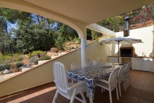 a table with chairs and an umbrella on a patio at Club Villamar - Claire in Tossa de Mar