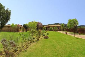 a green yard with trees and a building in the background at Club Villamar - Descanso in Platja  d'Aro