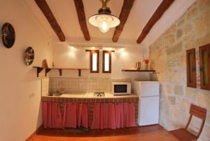 a kitchen with a counter with a microwave and a refrigerator at Club Villamar - Descanso in Platja  d'Aro
