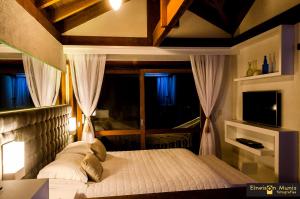 a bedroom with a large bed with a window at Solar Mirador Exclusive Resort e SPA in Praia do Rosa