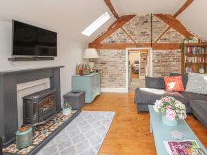 a living room with a couch and a fireplace at The Old Coach House in Mold