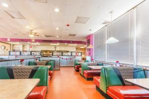 un restaurant avec des tables et des chaises vertes et rouges dans l'établissement Americas Best Value Inn of Elk City, à Elk City