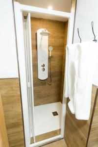 a shower in a small bathroom with white towels at Flamingo Friendly Holiday Home in Playa del Ingles