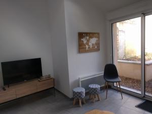 a living room with a flat screen tv next to a window at Maison Jean-Moulin, jardin, spacieuse, 24h Mans, zoo, Prytanée, 3 chbres, 6 pers in La Flèche