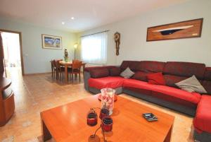 uma sala de estar com um sofá vermelho e uma mesa em Club Villamar - Lucerna em Sant Antoni de Calonge
