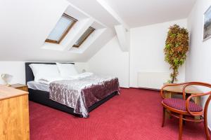 a bedroom with a bed and a red carpet at Mini hotel Na konci in Krupka +42 photos