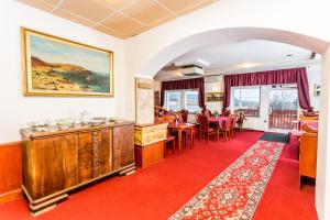 a living room with a red carpet and a dining room at Mini hotel Na konci in Krupka - Marsov