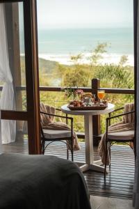 a table with a tray of food on a balcony at Solar Mirador Exclusive Resort e SPA in Praia do Rosa