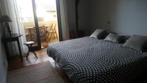 um quarto com uma cama com um edredão preto e branco em Margouillat chambre d'hôte em Figeac