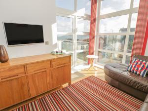 a living room with a flat screen tv and a couch at Seaview in Benllech