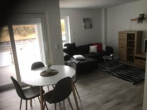 ein Wohnzimmer mit einem Tisch und einem Sofa in der Unterkunft Ferienwohnung Wildes Wässerchen in Bad Hersfeld