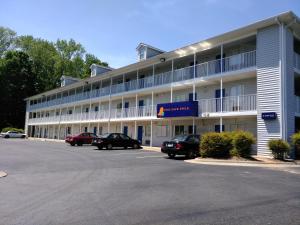 a large white building with cars parked in a parking lot at InTown Suites Extended Stay Charlotte NC - Albemarle in Charlotte