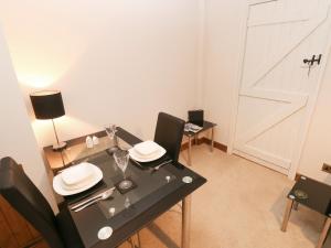 a dining room with a black table and chairs and a door at The Granary in Knelston