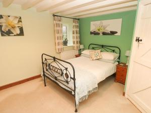 a bedroom with a bed and a green wall at The Granary in Knelston